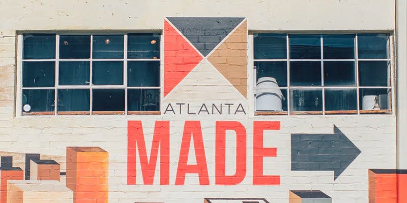 Brick wall mural with 'Atlanta Made' text showcasing bold fonts in an industrial setting.