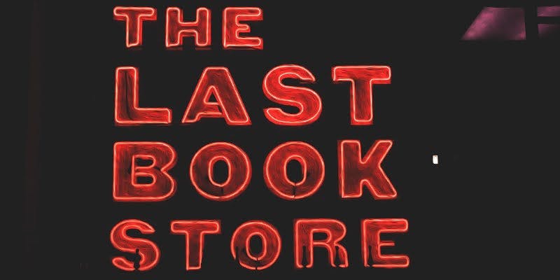 Neon sign reading 'The Last Book Store' in bold, glowing red letters against a dark background.